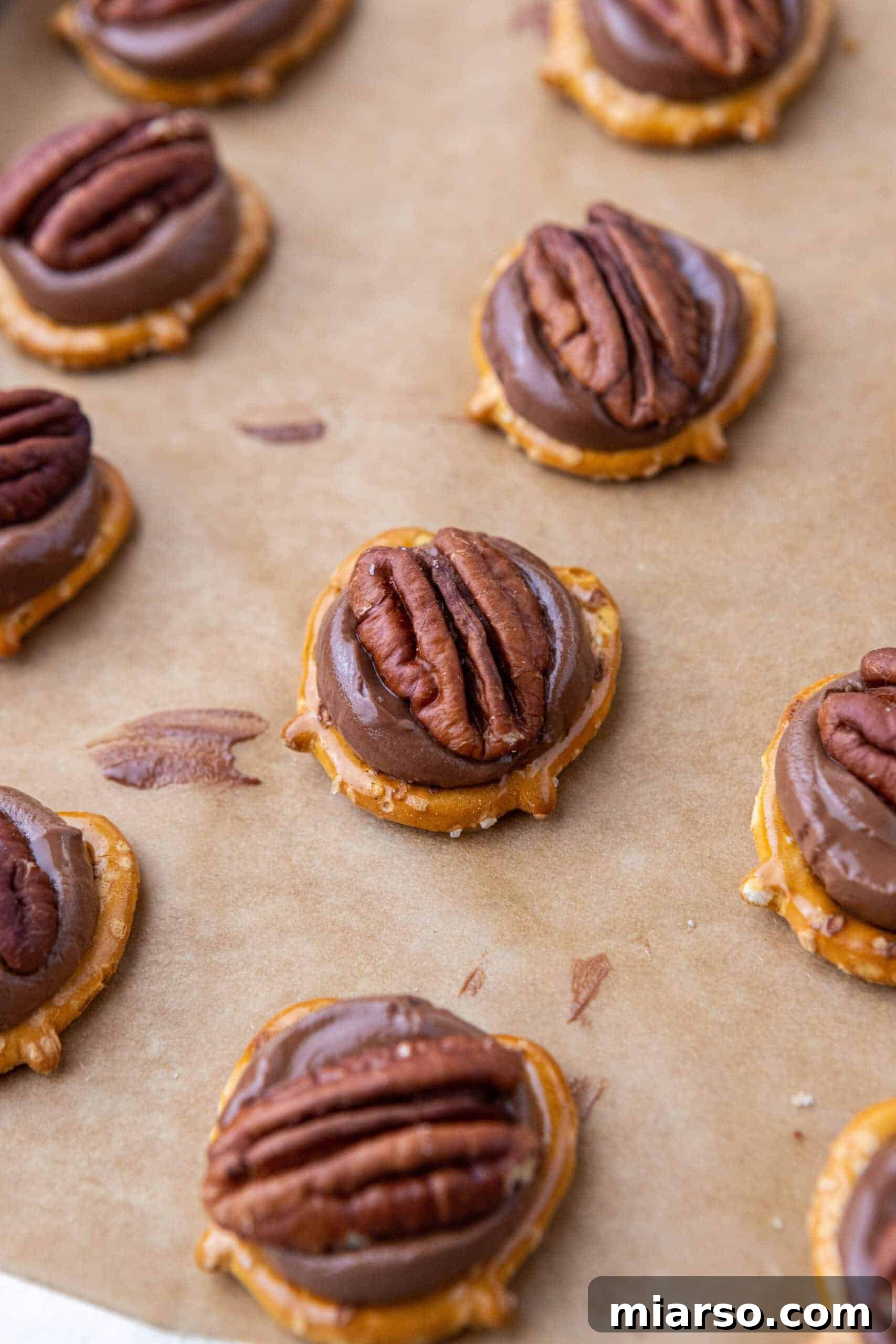 Freshly baked Rolo Pretzel Turtles with pecans pressed onto melted Rolos.