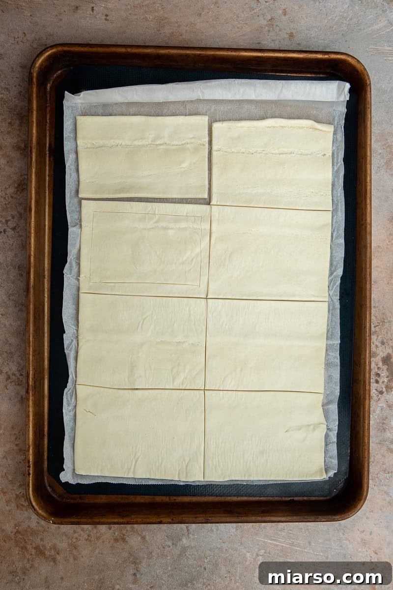 Cranberry Cheese Danish Revival 5 Unrolled puff pastry sheet on parchment paper, ready for cutting.