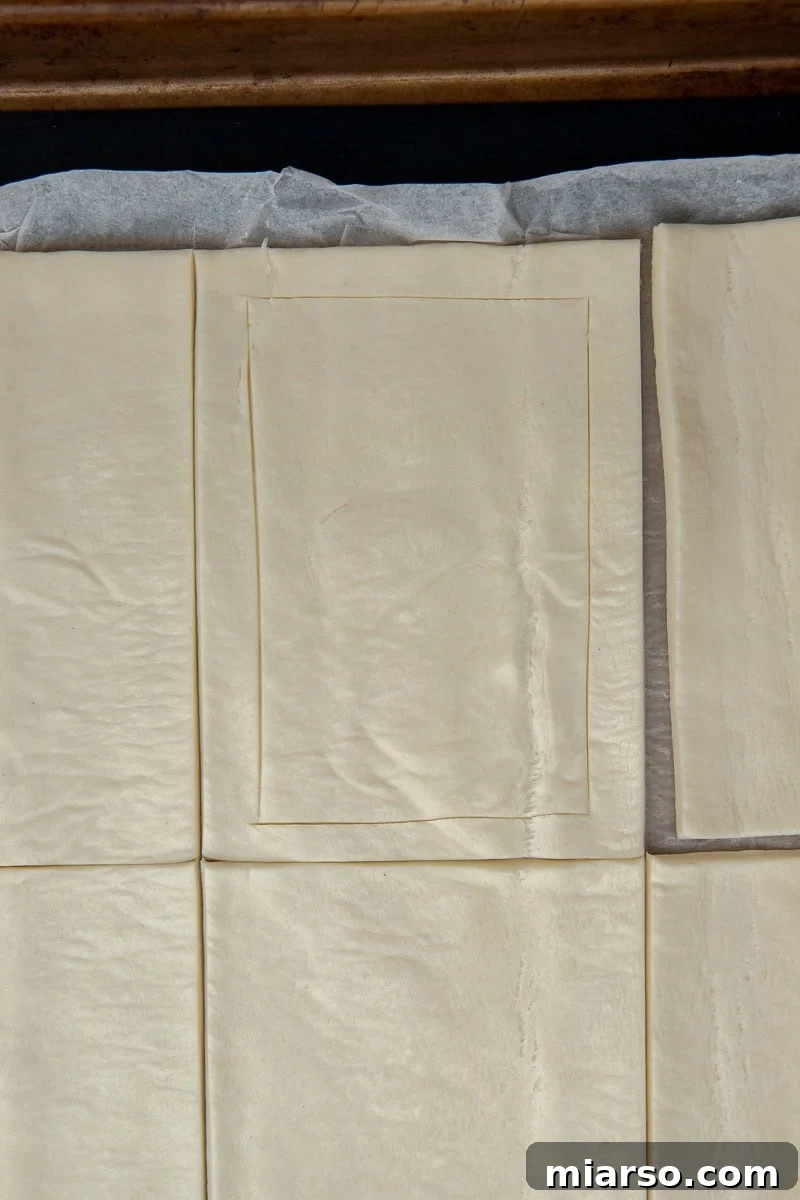 Cranberry Cheese Danish Revival 6 Puff pastry sheet scored into rectangles, with centers pricked with a fork.