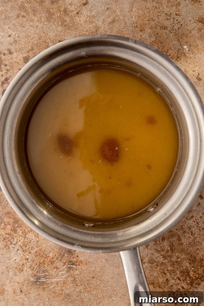 Water, brown sugar, and granulated sugar are added to a saucepan, ready to be heated and transformed into syrup.