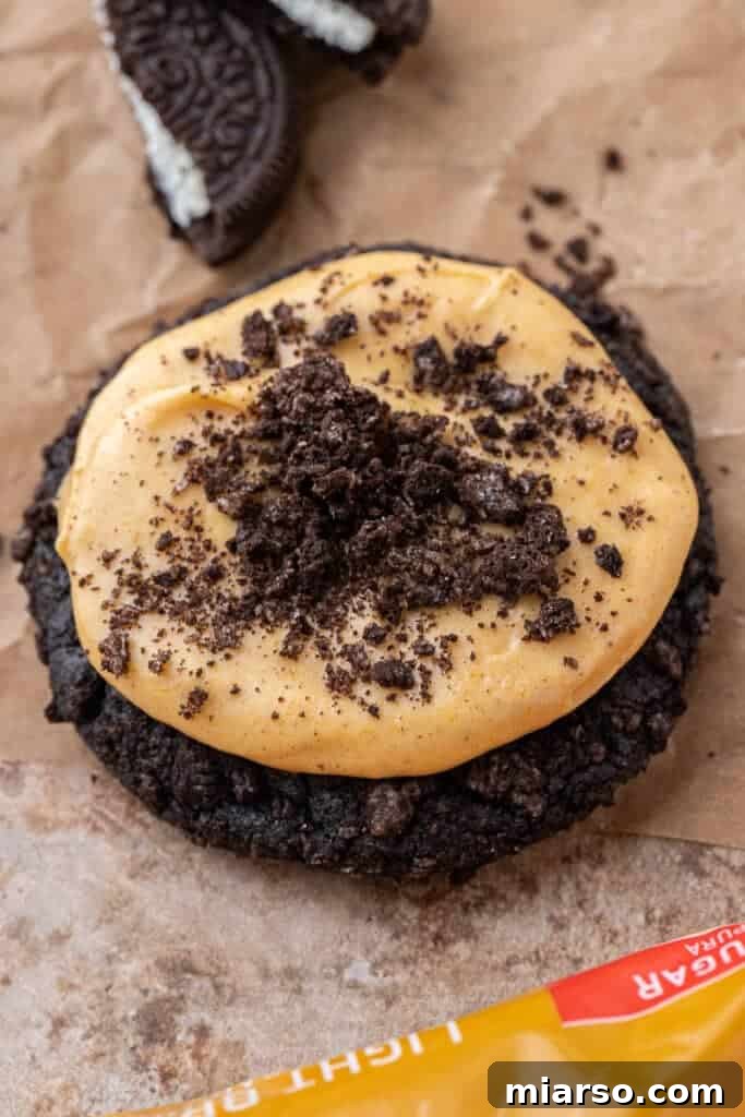 Decadent Crumbl Chocolate Pumpkin Cheesecake Cookies 14 A single perfectly frosted chocolate pumpkin cheesecake cookie, showcasing its rich dark cookie base and creamy pumpkin topping