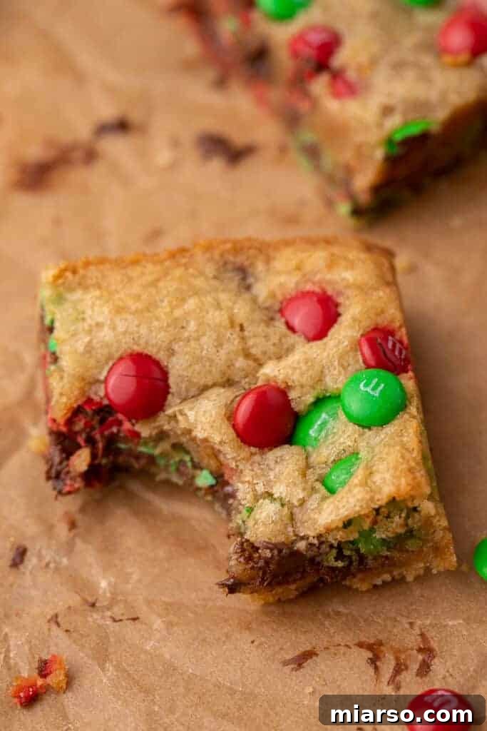 Irresistible Holiday M&M's Blondies 12 A Christmas blondie with a bite taken out of it, revealing its soft interior and M&M's