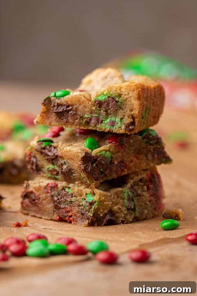 Irresistible Holiday M&M's Blondies 4 A stack of perfectly sliced Christmas blondies, showcasing their fudgy texture and M&M's