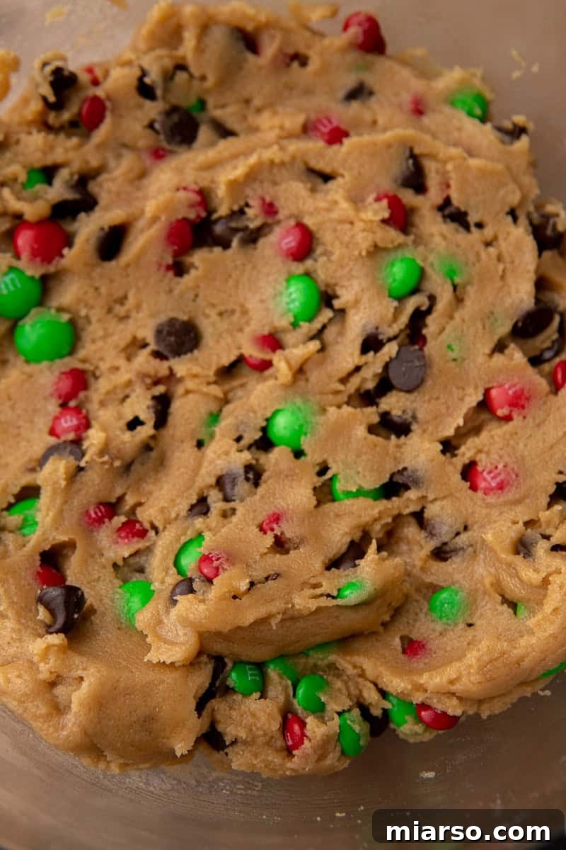 Irresistible Holiday M&M's Blondies 7 Fully mixed cookie dough with chocolate chips and M&M's in a bowl