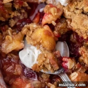 Spoon of cranberry apple crisp and ice cream
