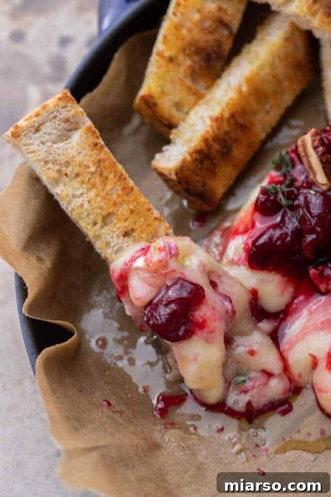 Baked Brie served with various accompaniments like toast and fruit