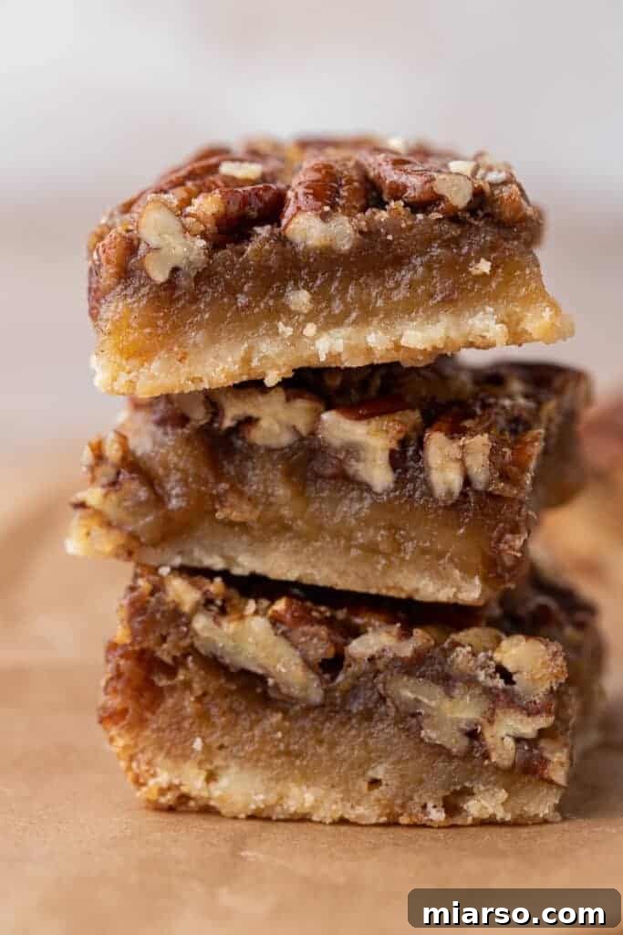 A perfectly stacked pile of homemade pecan pie bars, ready to be enjoyed.