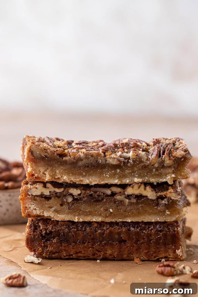Several delicious pecan pie bars stacked on a plate, ready to be served.