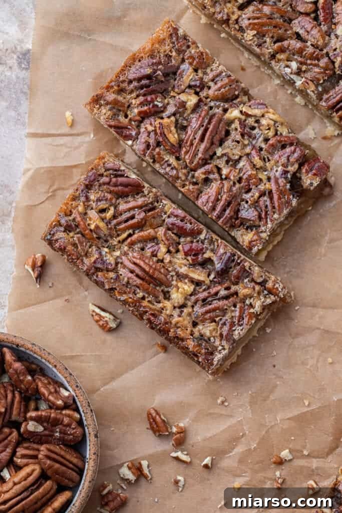 A perfectly sliced pecan pie bar showcasing its layers of crust and nutty filling.