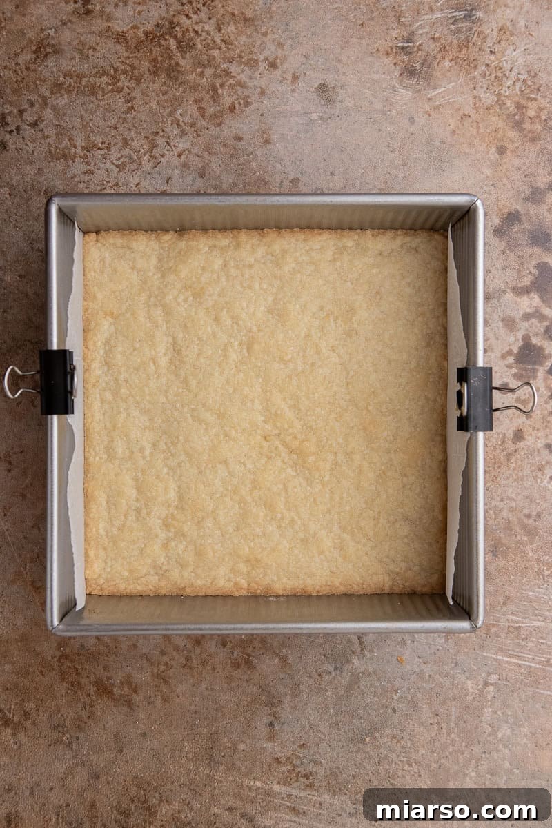 Shortbread dough pressed into a baking pan, ready for its first bake.