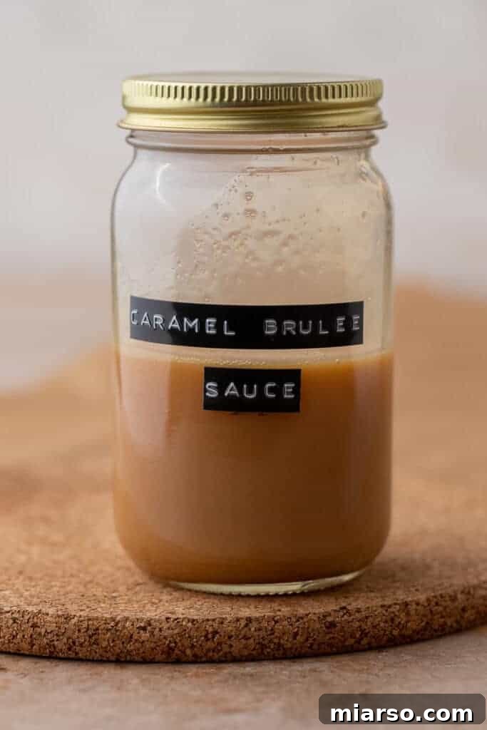 Homemade Starbucks Caramel Brulee Sauce stored in a glass jar with gold lid on a cork mat