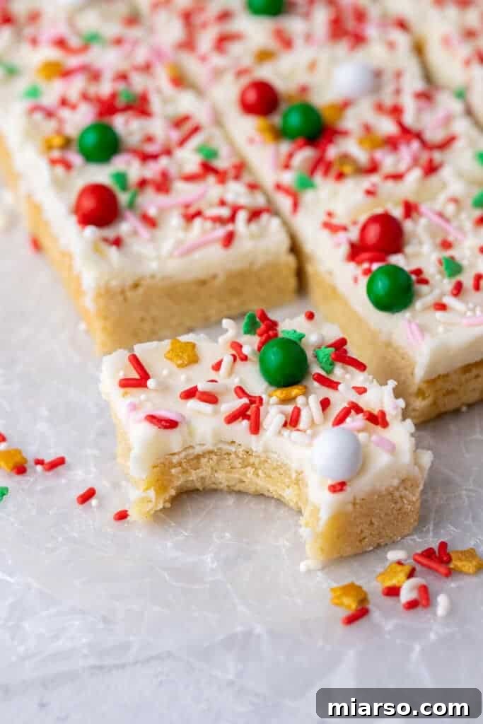 A sugar cookie bar with a bite taken out, revealing its soft and chewy texture