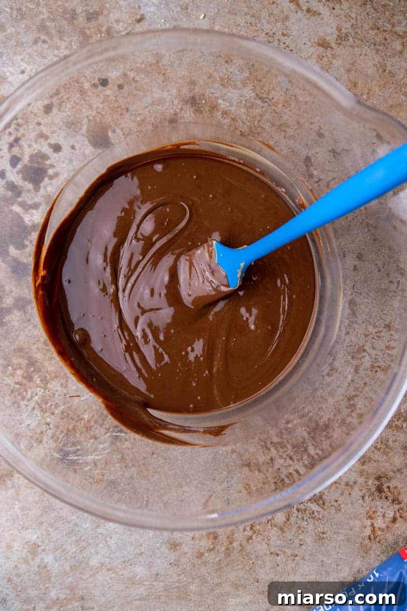 Melted chocolate and peanut butter in a bowl, a key step for muddy buddies
