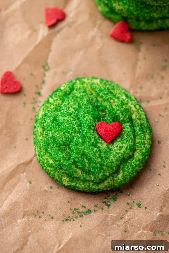 Grinch's Heart-Melting Sugar Cookies 2 Vibrant green Grinch sugar cookies with red heart sprinkles, ready for Christmas