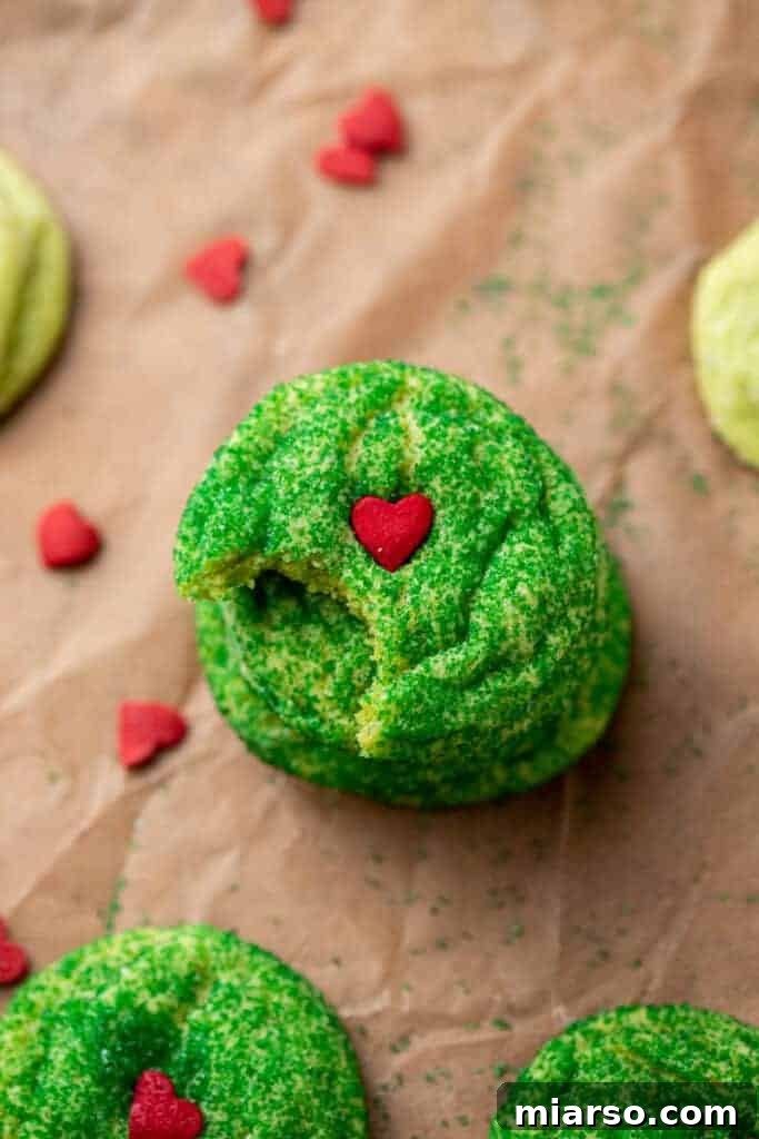 Grinch's Heart-Melting Sugar Cookies 14 Grinch sugar cookie with a bite taken out, showing the soft, green interior