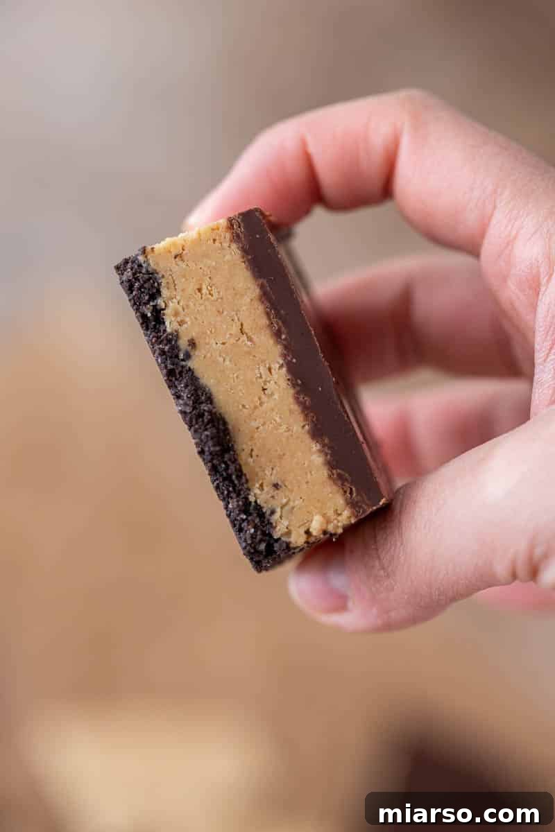 No-Bake Peanut Butter Oreo Bars 11 Hand holding peanut butter Oreo bars
