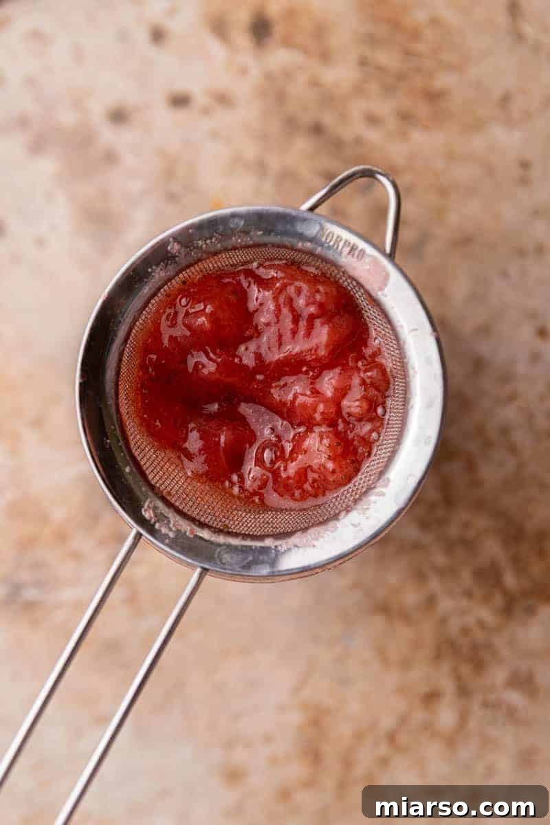 Homemade Strawberry Milk Made Easy 6 mashed strawberries in a sieve