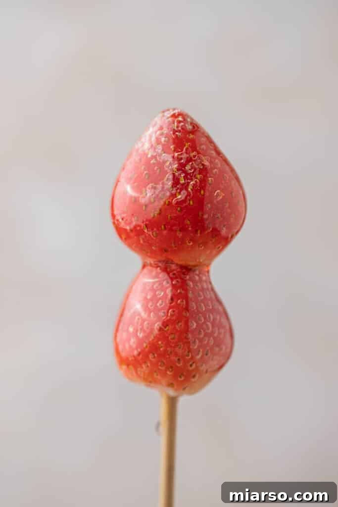 Close up of Strawberry tanghulu, showcasing the glossy candy coating on fresh strawberries.