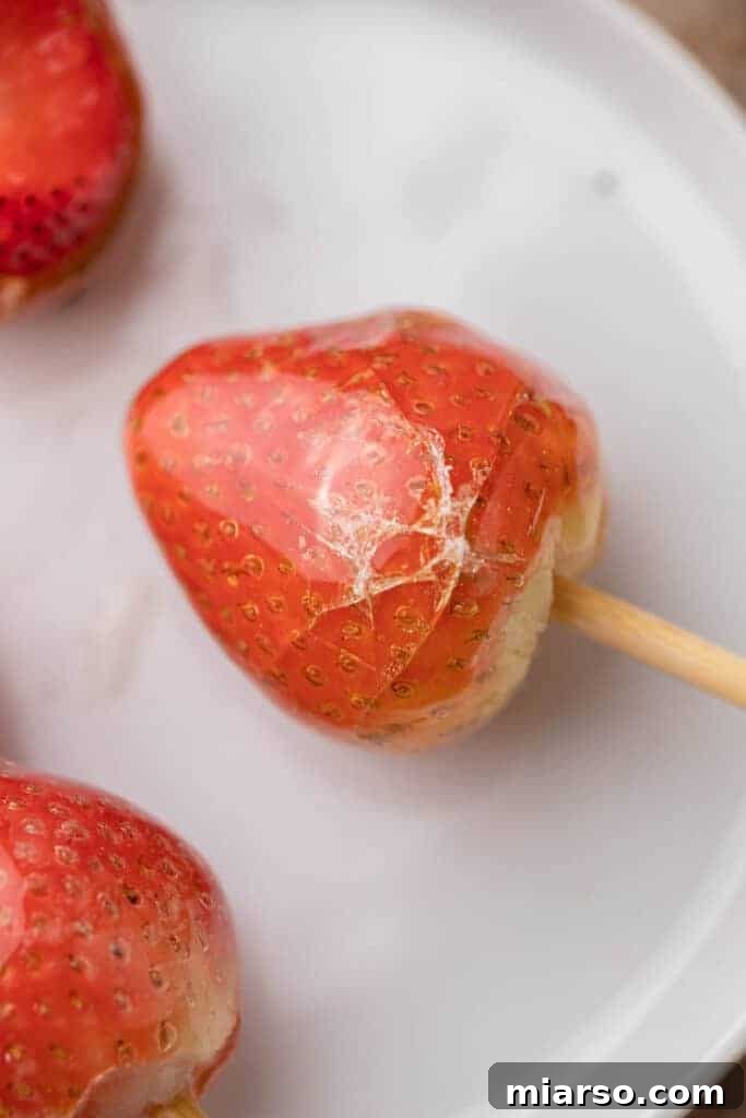 Tanghulu recipe featuring freshly candied strawberries on a white background, highlighting the glossy coating.