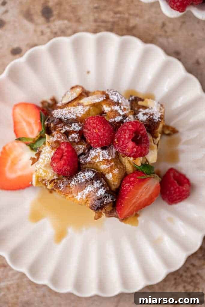 Overhead shot of brioche French toast casserole in a baking dish, garnished with almonds.