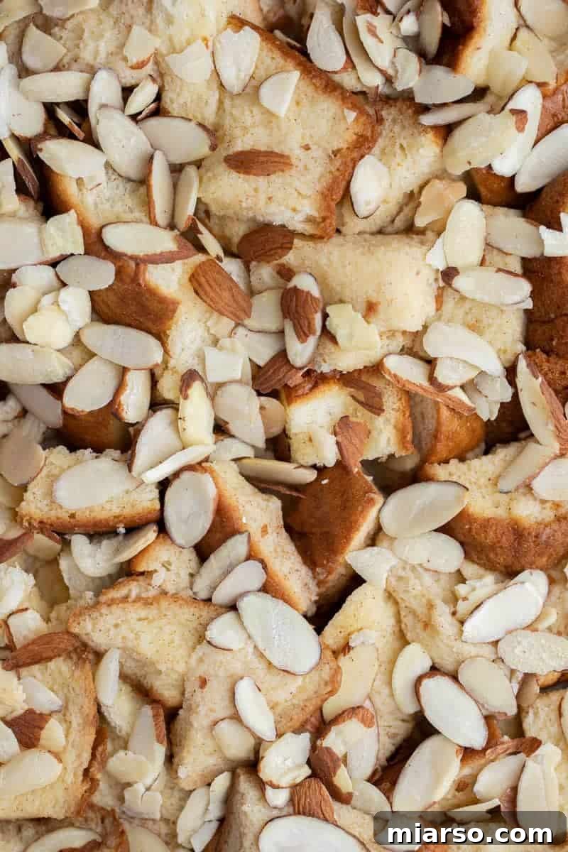 Unbaked brioche casserole topped with thinly sliced almonds.