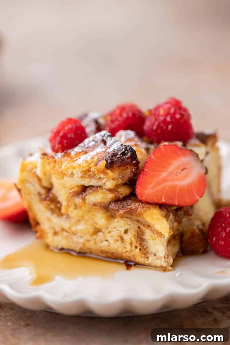 A perfectly baked slice of brioche French toast casserole on a white plate.