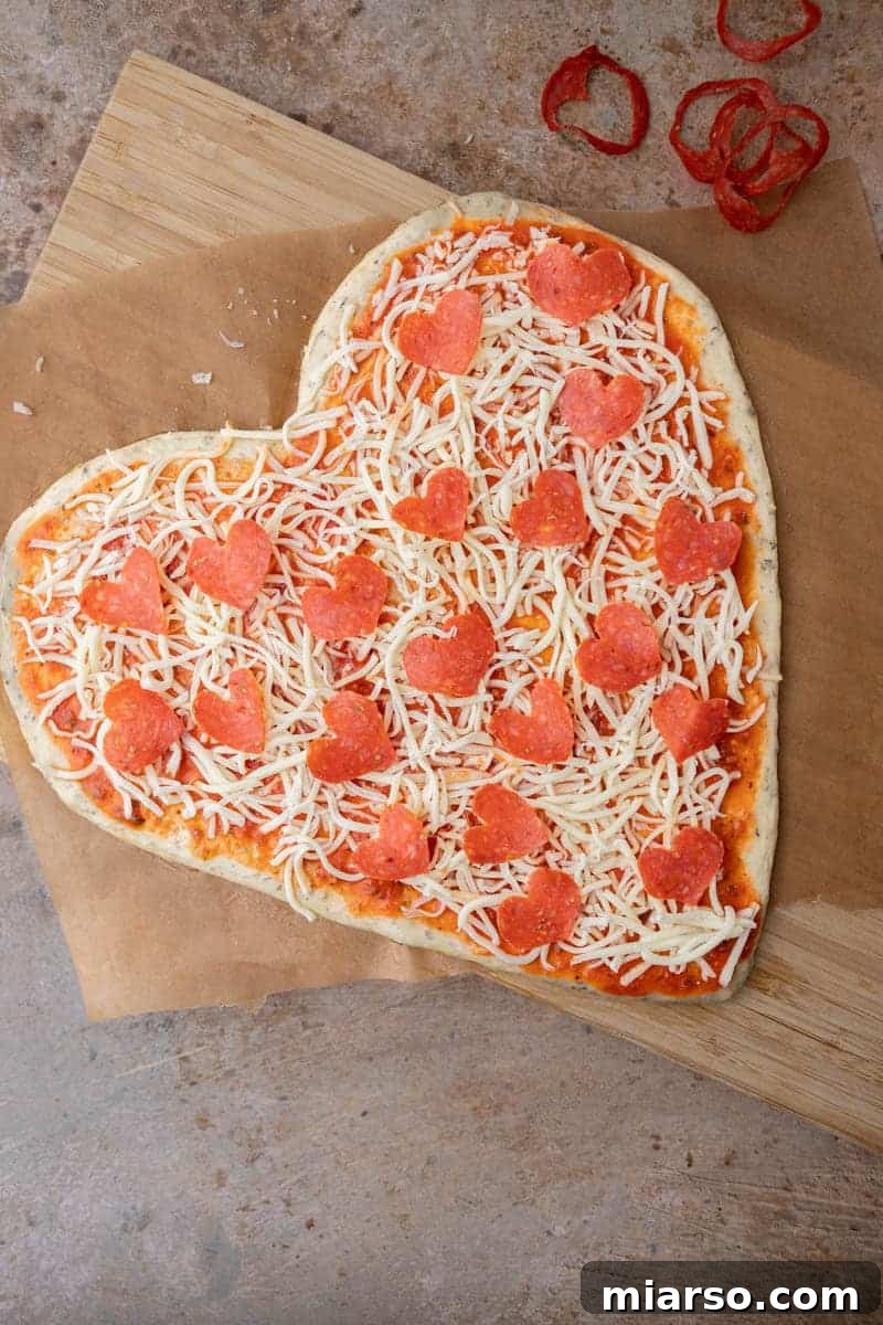 Arranging adorable heart-shaped pepperoni onto the cheesy Valentine's Day pizza
