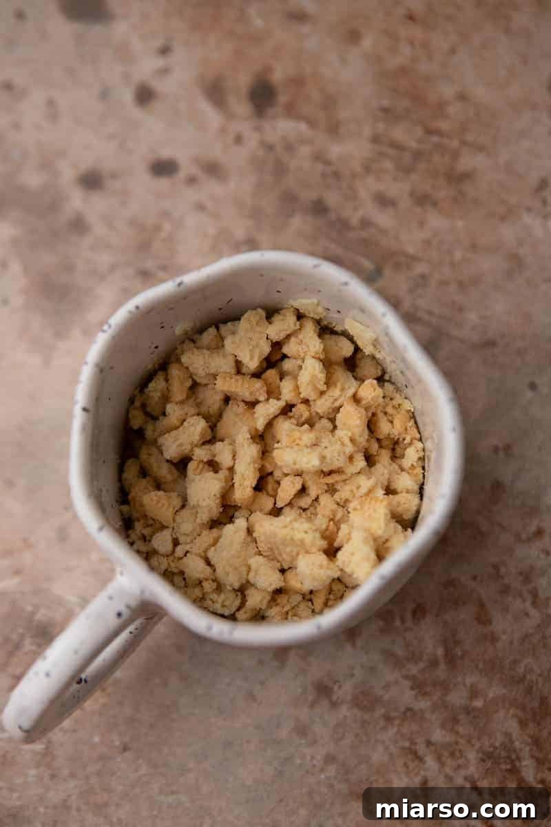 Molten Gold Oreo Mug Cake: Just 3 Ingredients 4 Crushed Golden Oreos at the bottom of a mug, ready for mixing.