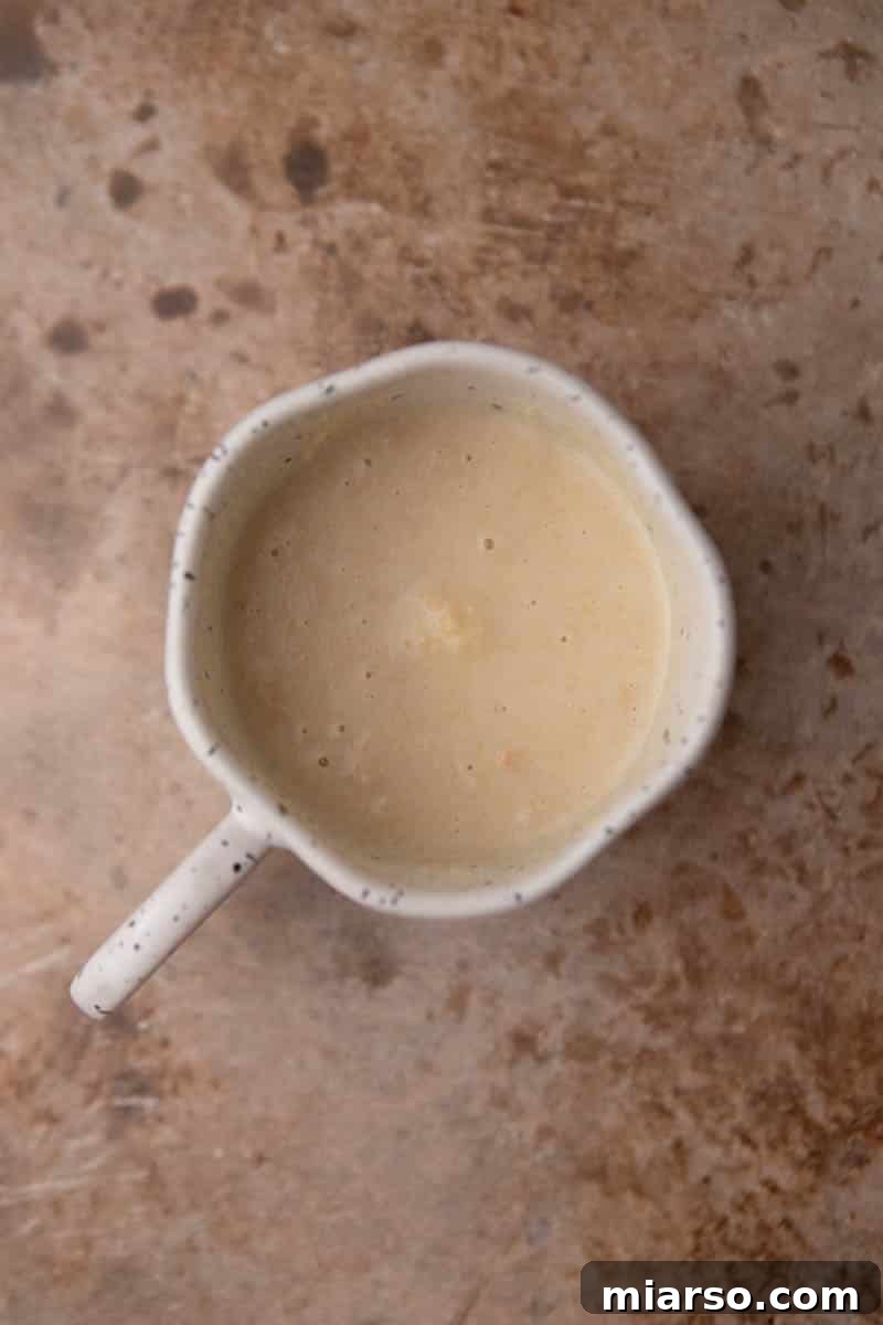 Molten Gold Oreo Mug Cake: Just 3 Ingredients 5 Smooth Golden Oreo mug cake batter in a mug with a truffle nestled in the center.