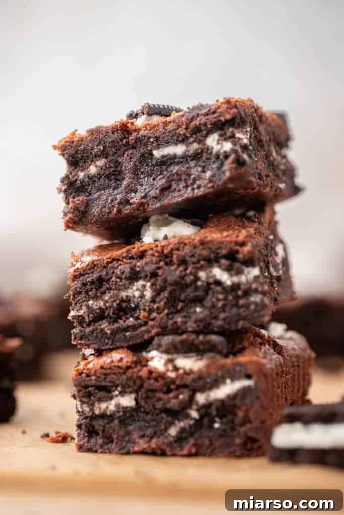 Decadent Oreo Fudge Brownies 12 A stack of perfectly baked fudgy Oreo brownies, showcasing their irresistible crinkly tops.