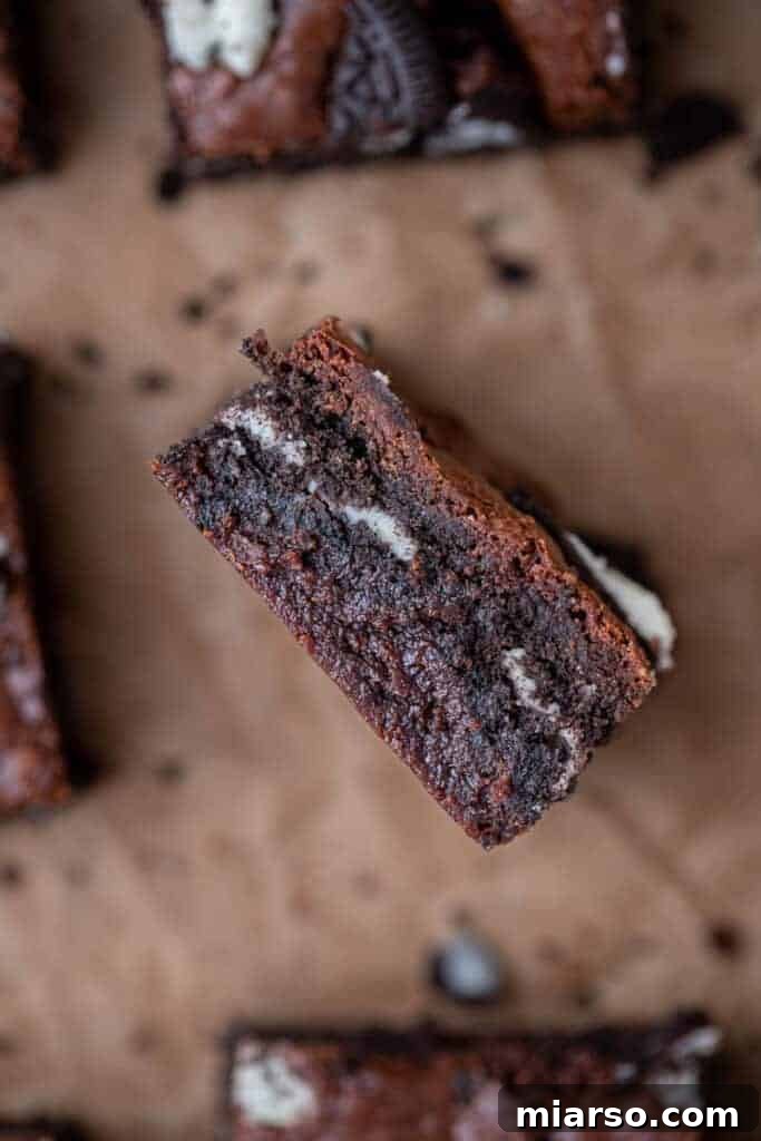 Decadent Oreo Fudge Brownies 4 A close-up shot of perfectly sliced fudgy Oreo brownies, showing their dense texture, chocolate chunks, and embedded Oreo pieces.