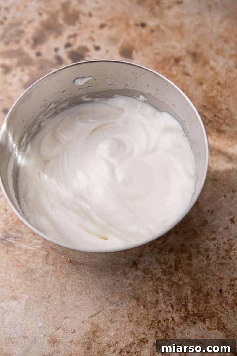 Fluffy whipped egg whites in a mixing bowl