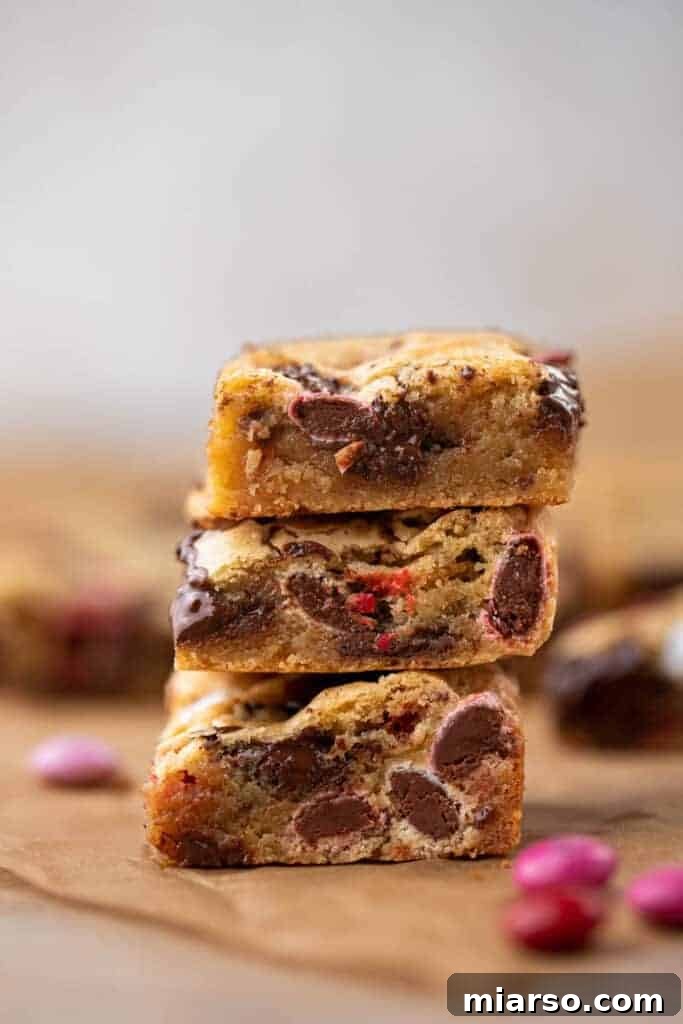 Stack of freshly baked Valentine's Day M&M's blondies on a cooling rack