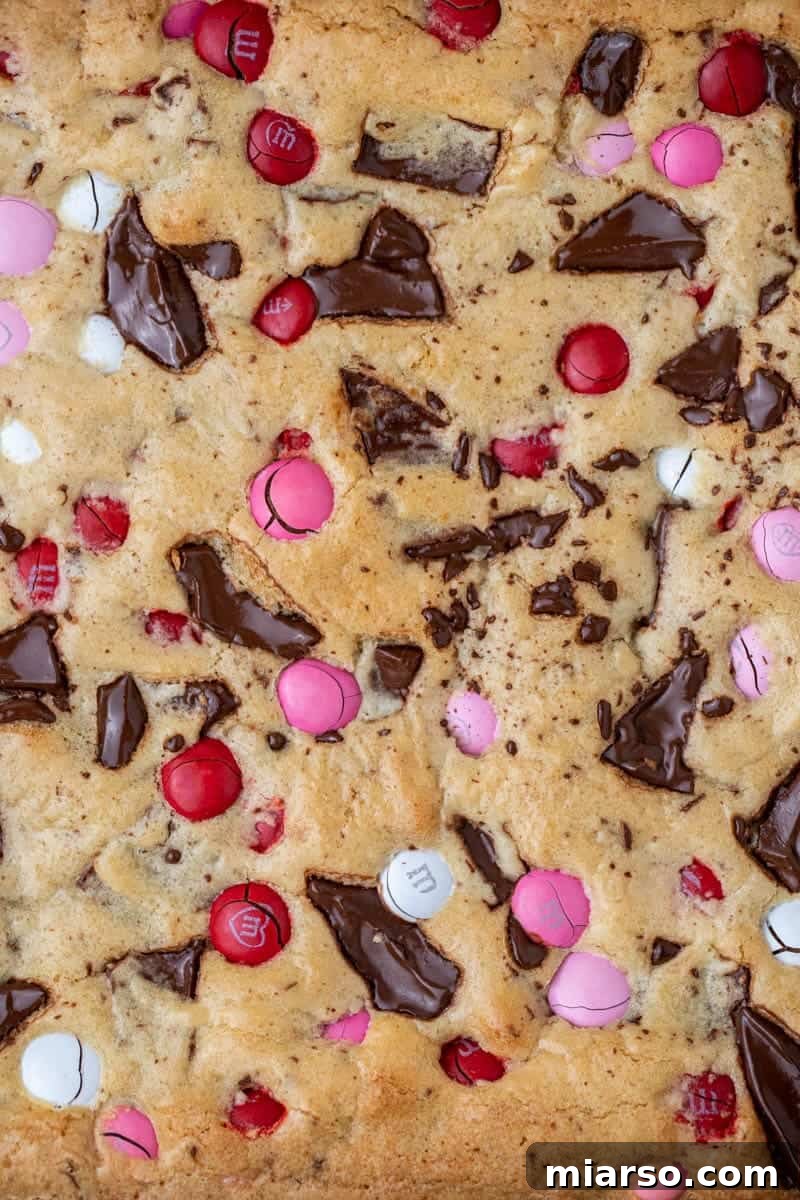 Freshly baked Valentine's Day M&M's blondies cooling in the pan, showcasing their beautiful crinkly tops