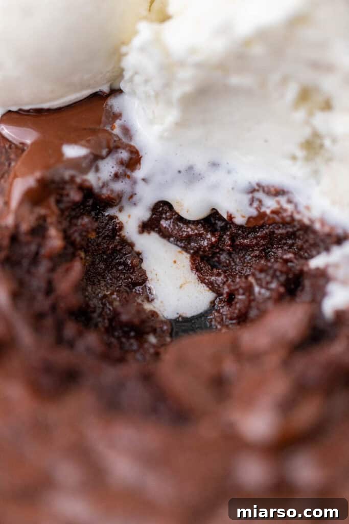 An extreme close-up of a warm, gooey skillet brownie, showing its moist interior and melted chocolate.