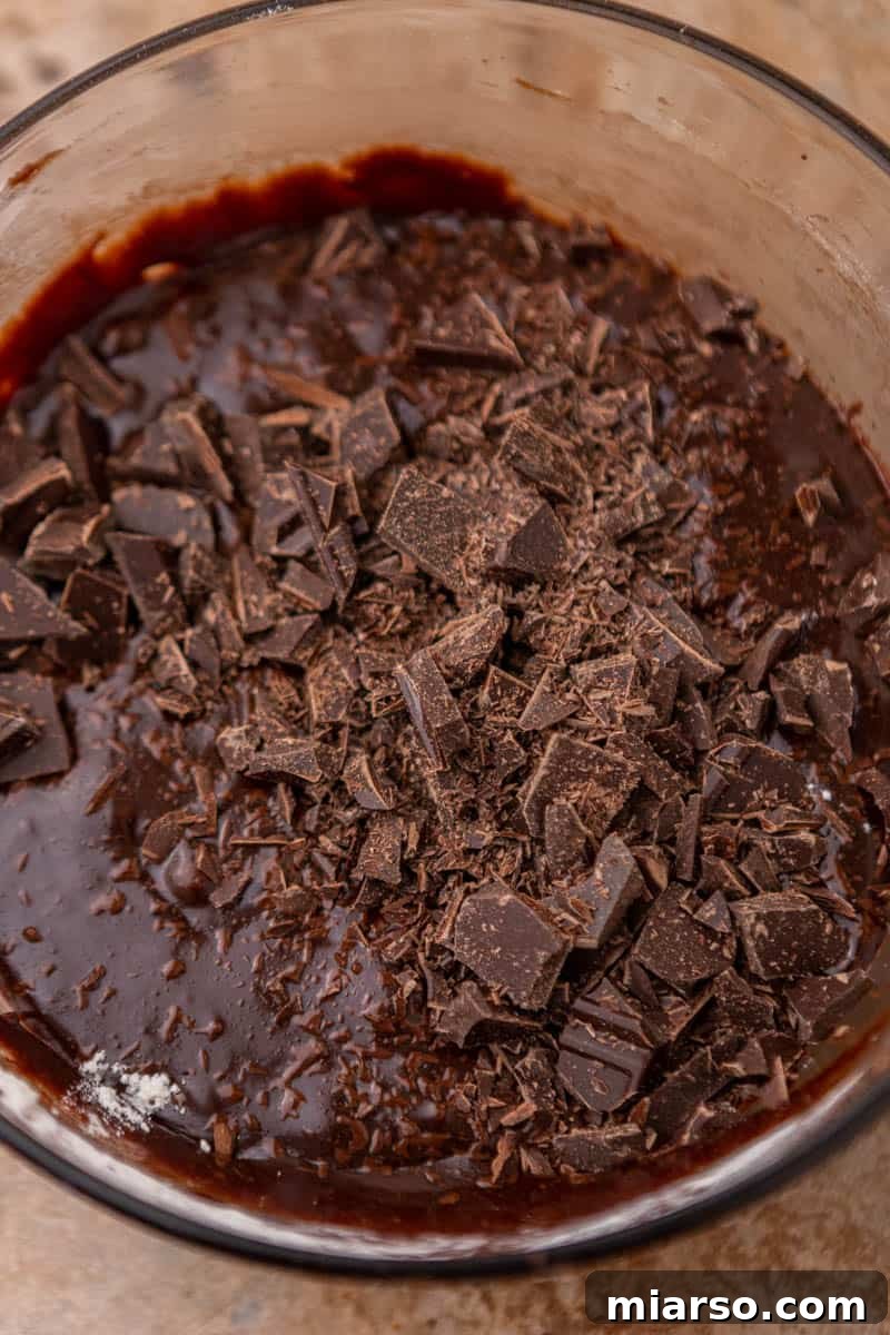 Whisking in eggs and vanilla into the brownie batter.