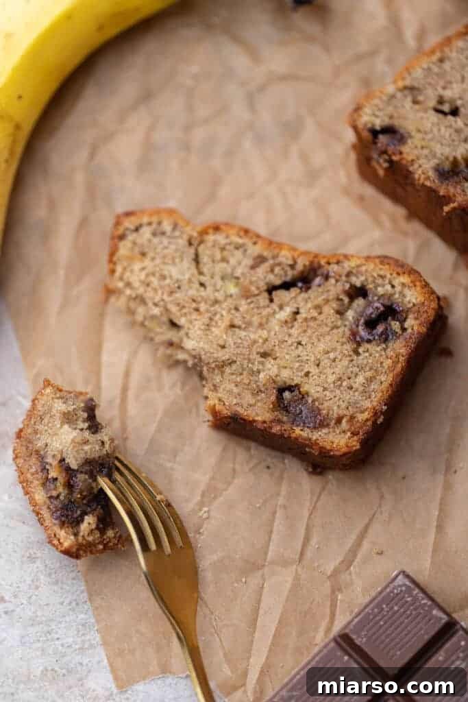 A thick slice of eggless banana bread with visible chocolate chunks