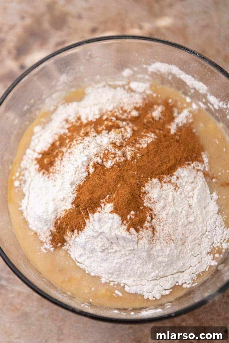 Dry ingredients being folded into wet ingredients for banana bread