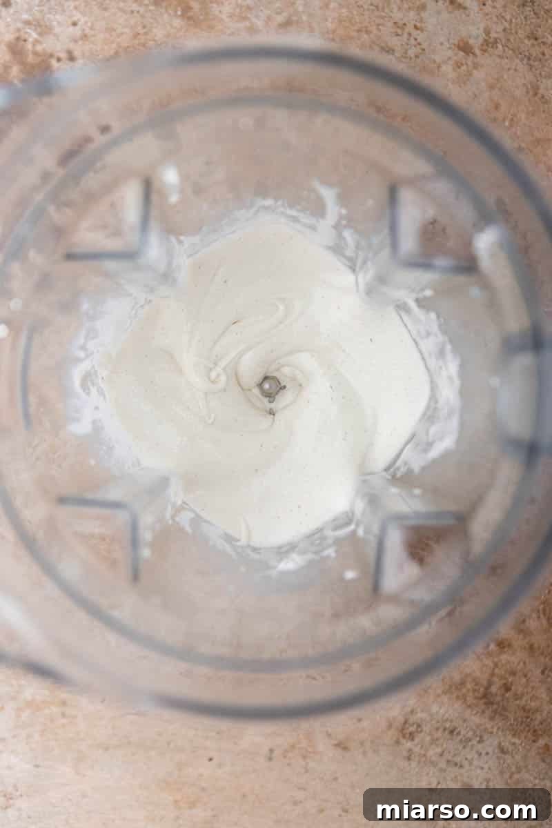 Blended creamy soft-serve ice cream mixture in a blender cup.