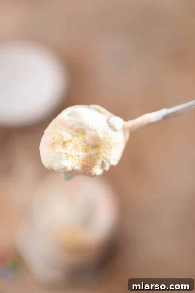 A spoon digging into a creamy homemade M&M's McFlurry.