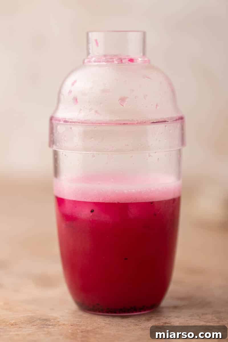 Shaker bottle with ingredients being vigorously shaken