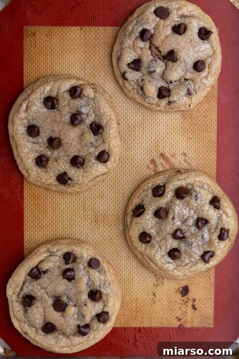 Chocolate stuffed chocolate chip cookies on a baking sheet before cooling