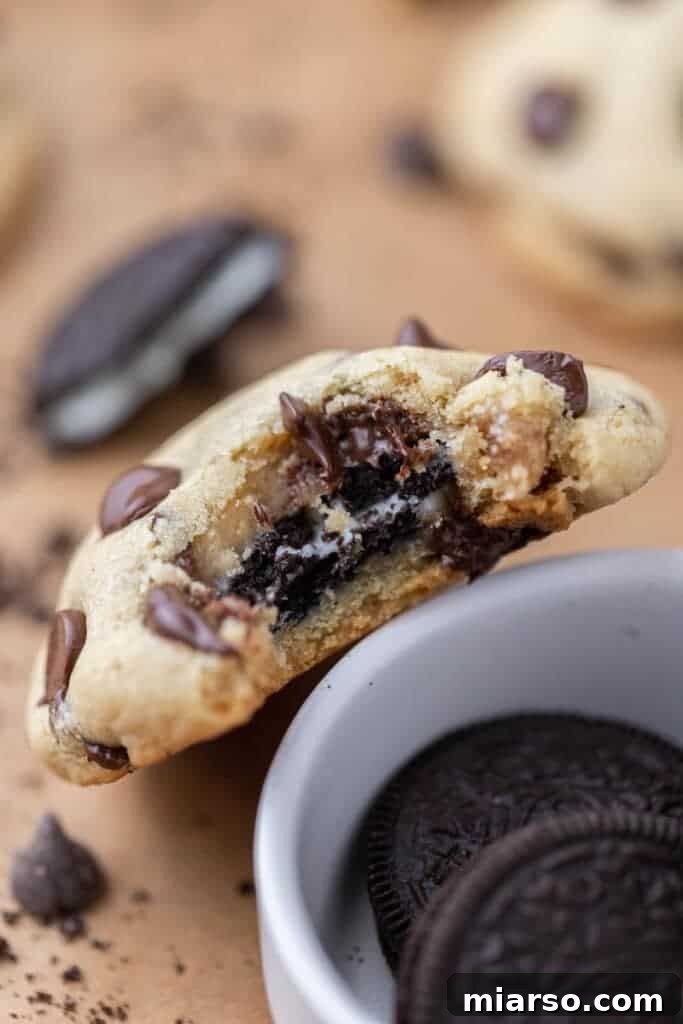 Oreo Stuffed Chocolate Chip Cookies Made Simple 5 A freshly baked Oreo stuffed cookie with a perfect bite taken out, revealing the soft chocolate chip cookie exterior and the whole Oreo within.
