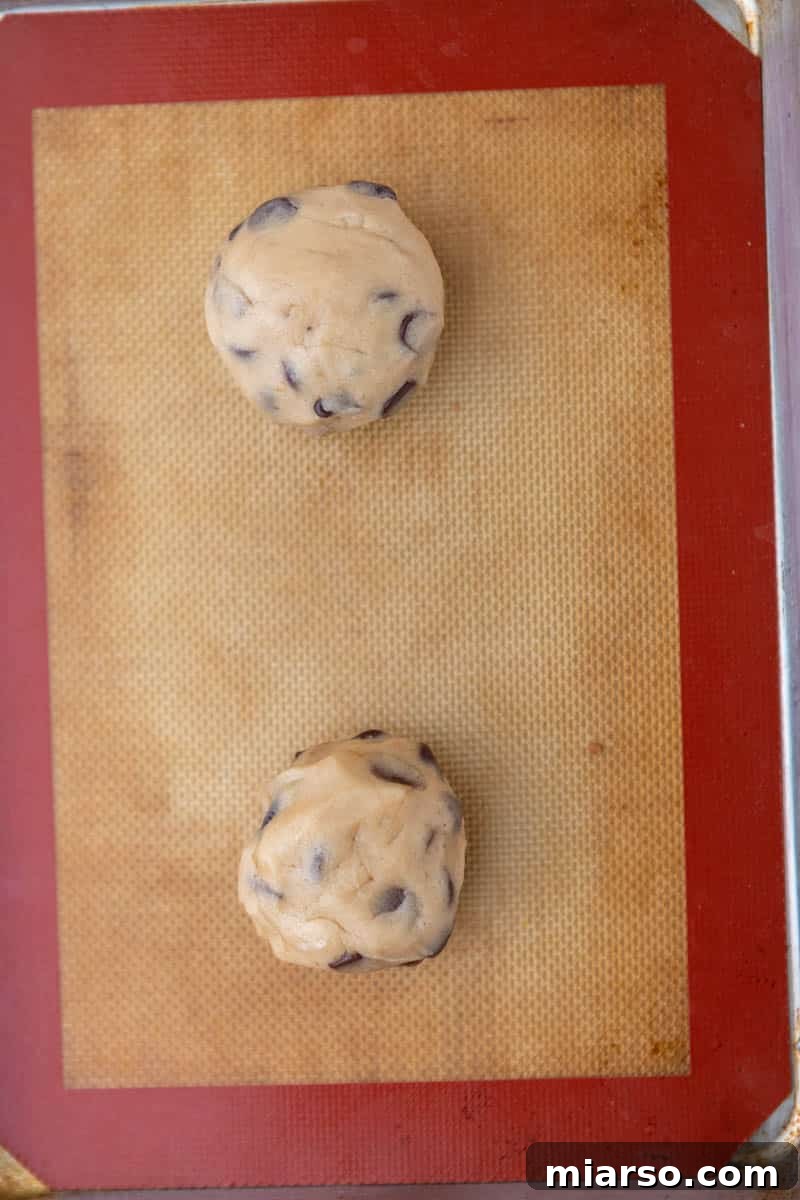 Oreo Stuffed Chocolate Chip Cookies Made Simple 10 Rounded balls of Oreo stuffed cookie dough perfectly spaced on a baking sheet, ready for the oven.
