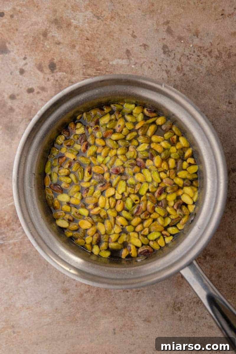 Starbucks Pistachio Syrup: Your Coffee's Delicious Upgrade 4 Pistachios infusing in sugar syrup in a saucepan on the stovetop