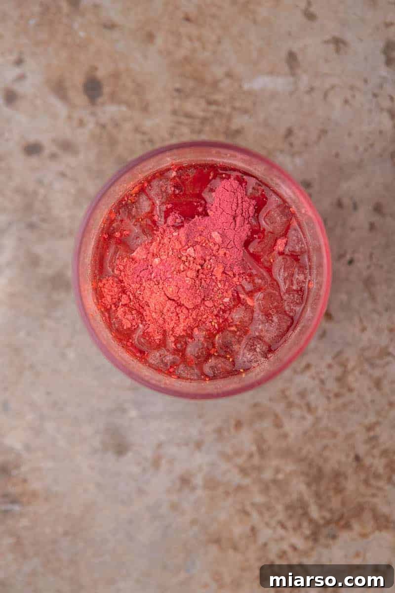 Craft Your Own Starbucks Strawberry Acai Refresher 4 Ingredients being measured into a cup