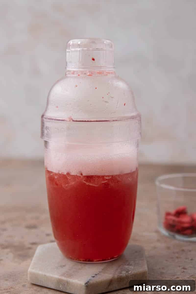 Craft Your Own Starbucks Strawberry Acai Refresher 5 Mixture being shaken in a cocktail shaker