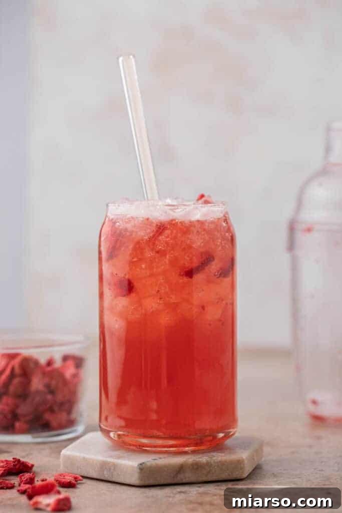 Craft Your Own Starbucks Strawberry Acai Refresher 9 Close-up of a Starbucks strawberry acai refresher with fruit inclusions
