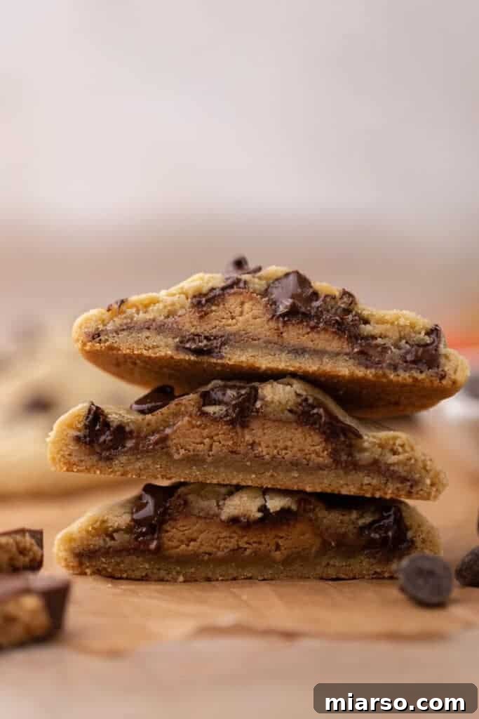 Quick Reese Peanut Butter Cup Chocolate Chip Cookies 2 Peanut butter stuffed chocolate chip cookies, freshly baked and golden brown on a cooling rack.