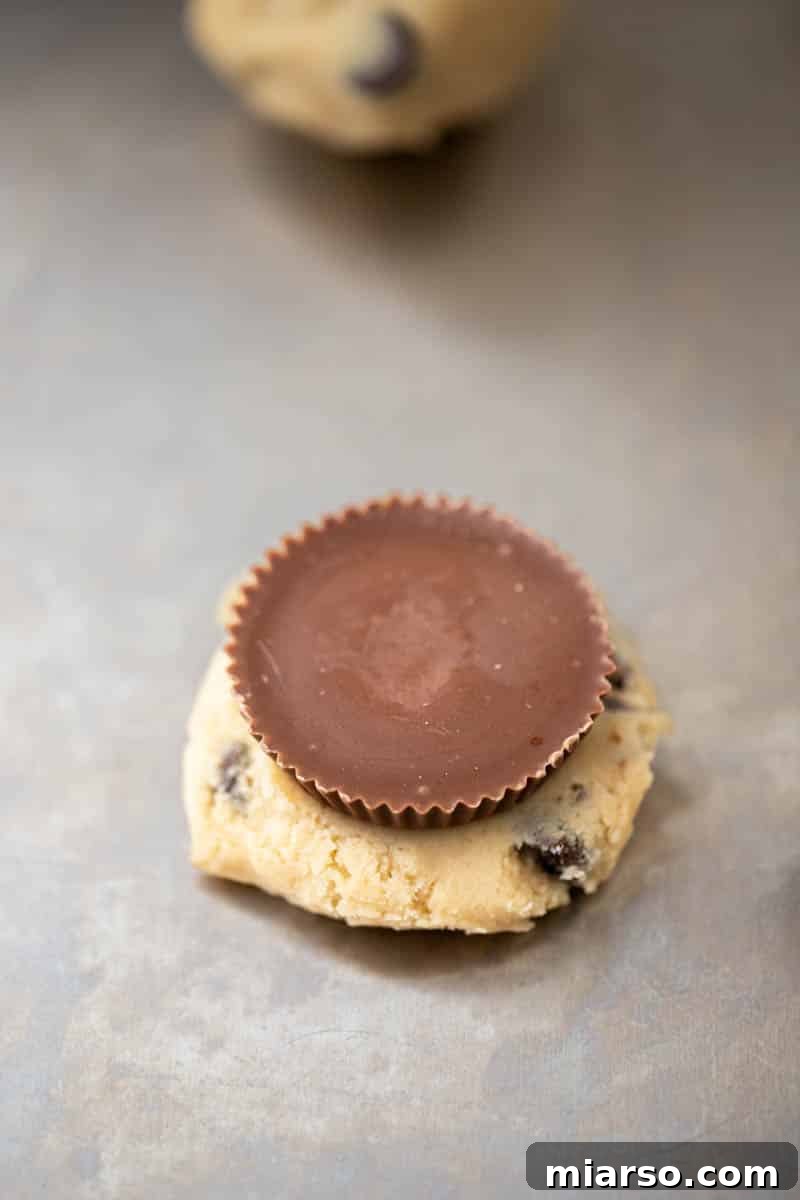 Quick Reese Peanut Butter Cup Chocolate Chip Cookies 7 Cookie dough balls on a baking sheet before stuffing.